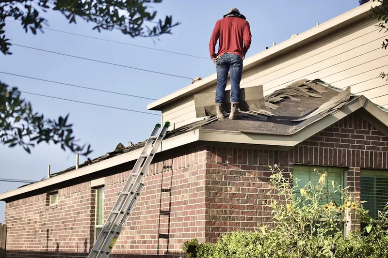Professional roofer working on a residential roof in Maloy